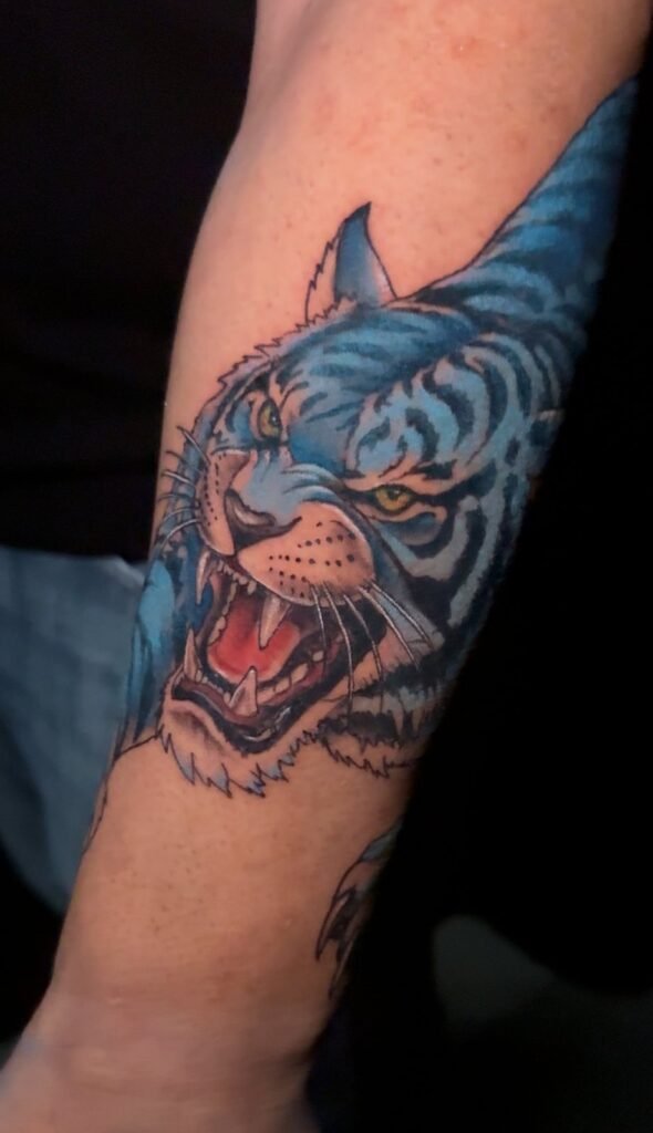 Blue tiger forearm tattoo by Monique Andujo