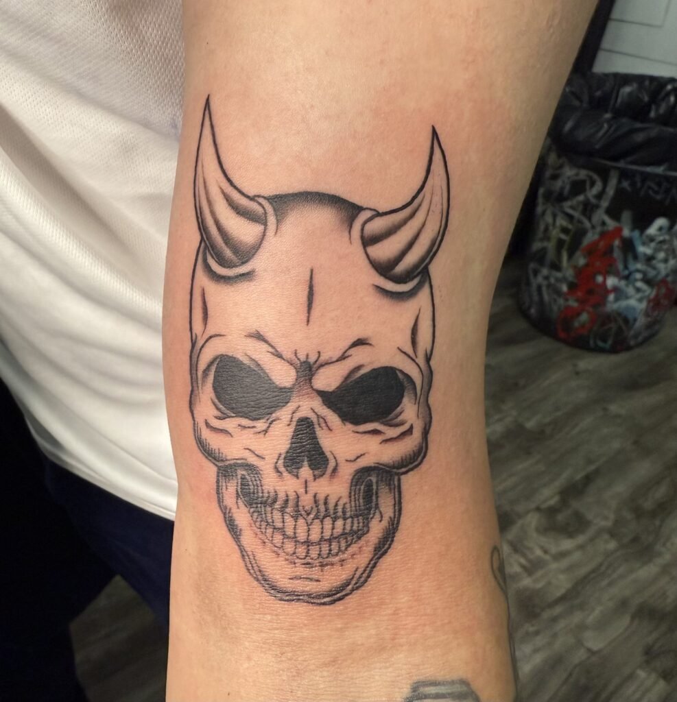 Devil horn skull forearm tattoo by Monique Andujo, Murrieta CA