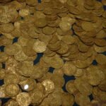 A hoard of ancient gold coins on a dark display