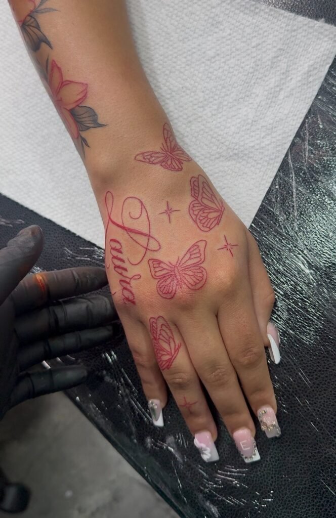 Red butterflies and name hand tattoo by Monique Andujo