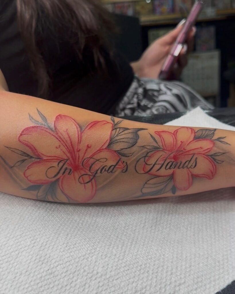 Red lilies 'In God's Hands' forearm tattoo by Monique Andujo